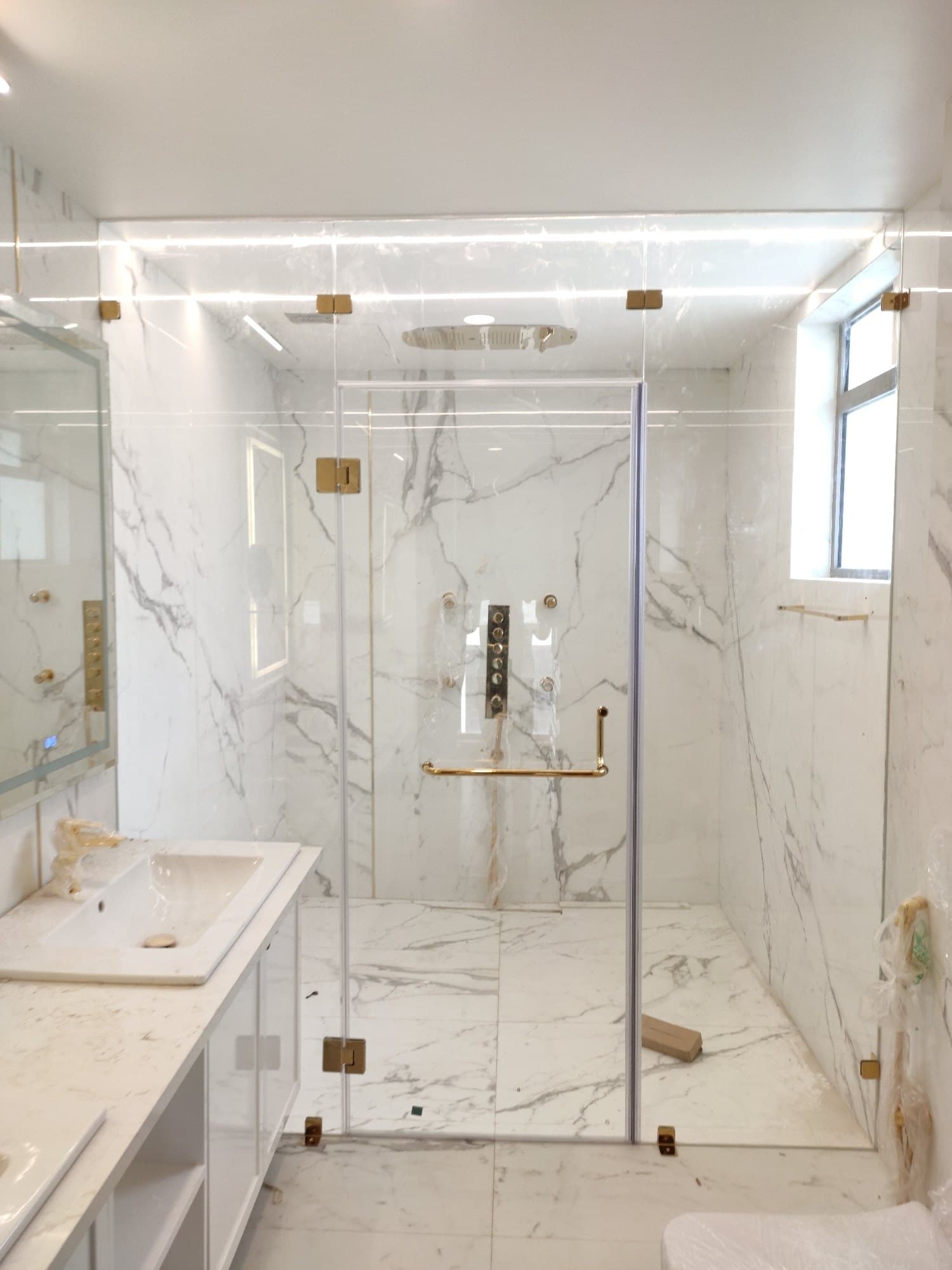 Glass shower enclosure with dark metal framing